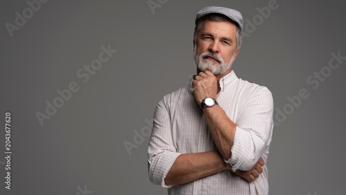 Fényképezés Smiling man wearing white shirt and flat cap, close-up