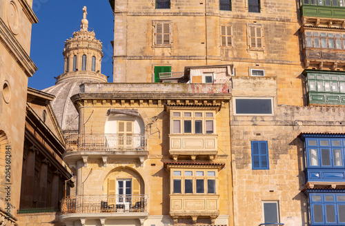 Tableau sur toile View of the Carmelite Church dome above a narrow street decorated with traditional festival banners in Valletta
