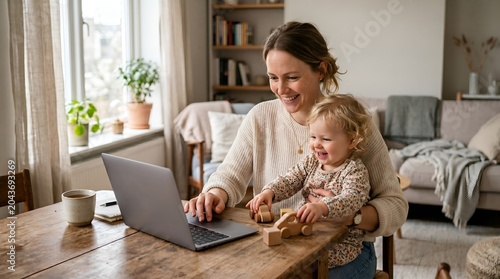 Woman working on laptop with toddler on her lap