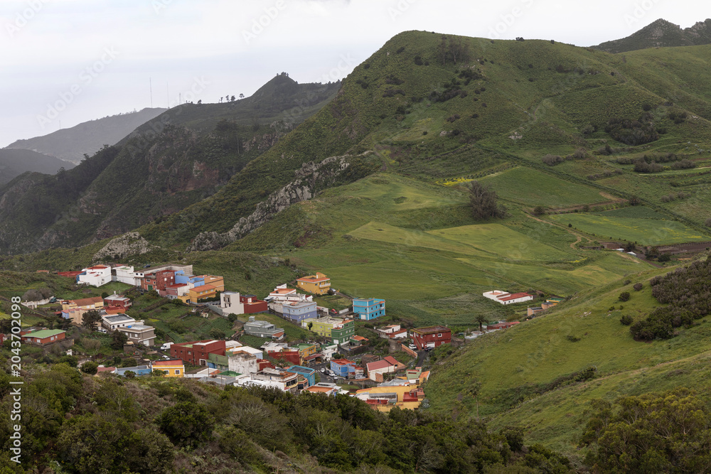 Fototapeta premium Colorful houses forming a village in a green mountain valley