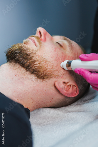 Fotografija Cosmetology treatment taking place on a persons face in a skincare clinic during