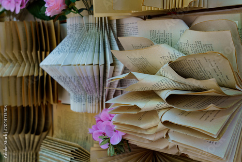 Creative art display using old books and paper flowers in a gallery setup