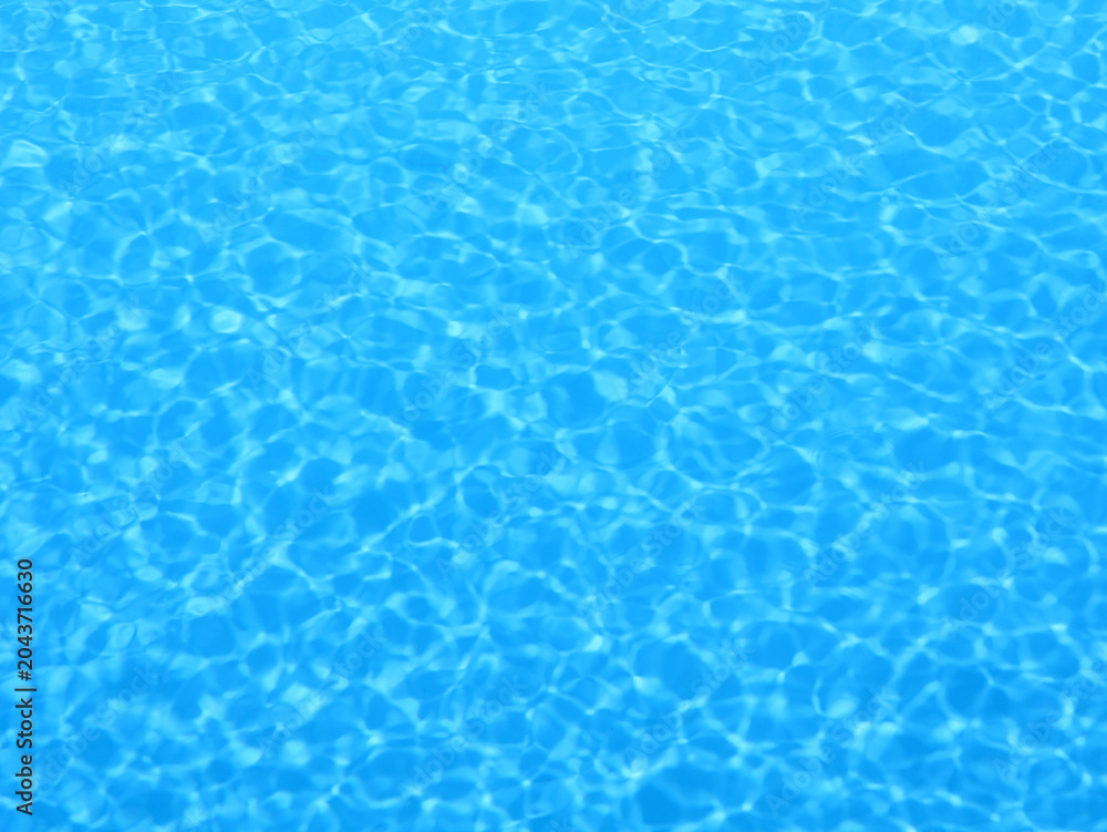 Obraz premium Sparkling blue pool water with light reflections. Background for summer themes.