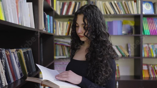 Teenage student girl working with a book in the school library
