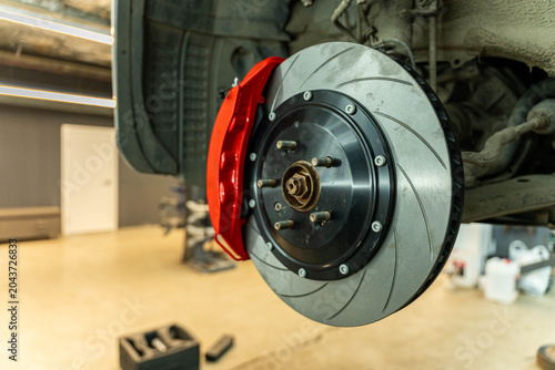 Foto Close-up view of a vehicle wheel brake assembly with a ventilated disc and red c