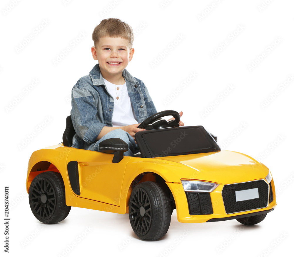 Fototapeta premium Little child driving toy car on white background