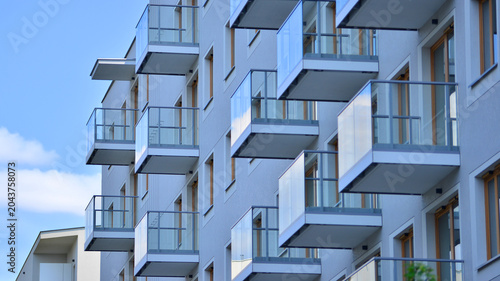 View of modern residential building with glass balconies and bright facade. Contemporary apartment building in european city. Concept of urban living and modern architecture. 