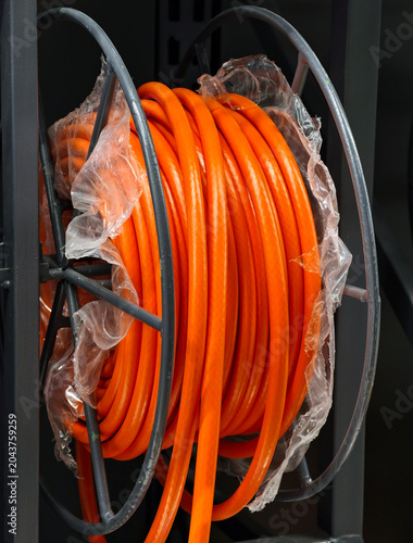 Tableau sur toile Red hose coiled and stacked is shown in a retail construction environment for cu