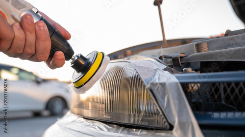 Принти на полотні The process of polishing car headlights outdoors.