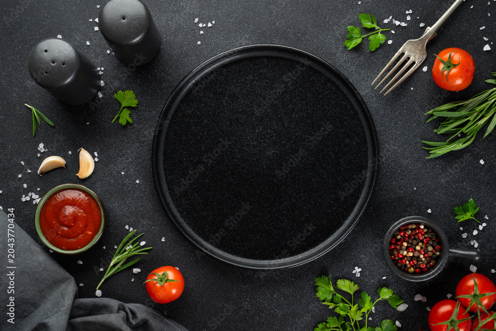 Fototapeta premium Black empty plate, Fresh herbs, spices and vegetables.