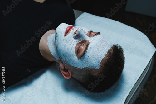Fotografie Cosmetology appointment for a man receiving facial treatment at a beauty salon i