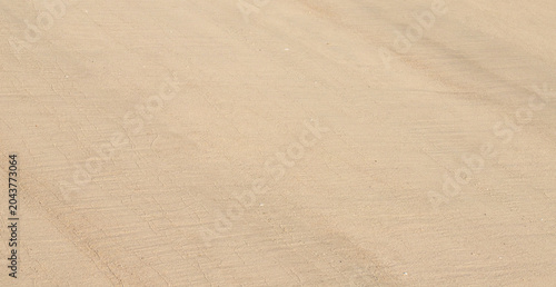 Smooth beige beach sand with soft diagonal lines as clean natural textured background