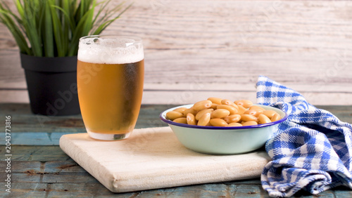 Cold Glass of Lager Beer and a Bowl of Lupin Beans on a Rustic Wooden Table