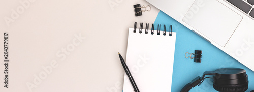 E-learning concept. Banner with laptop and stationery on a blue and gray background.