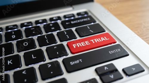 Red free trial button on laptop keyboard, symbolizing access to limited-time software or service.