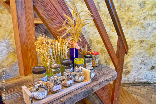 Foto Various grains and cereals displayed in jars on a rustic wooden bench with dried