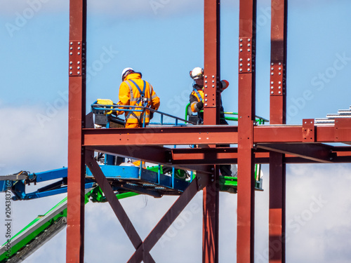 Structural steel erection, building construction, involving the placement and bolting of large steel beams to create frameworks. Ironworkers use specialized equipment  like aerial lifts and cranes. 