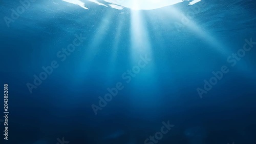 Sunlight rays penetrating deep blue ocean water, underwater background
