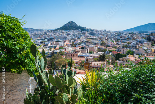 Elevated view from the rooftops of the Anafiotika neighborhood in Athens toward Lycabettus Hill, captured on a clear May morning.