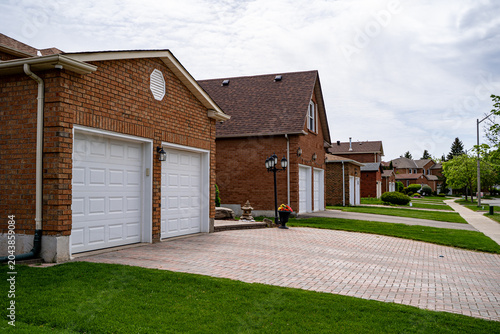 Fotografie View of suburban residential homes with driveways and garages.