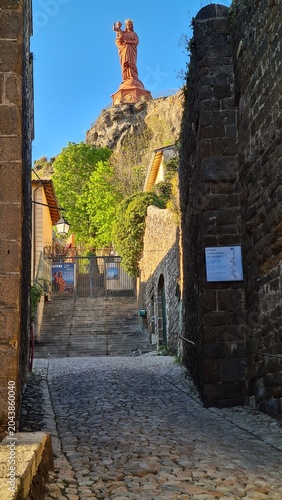 La magnifique statue de Notre-Dame de France vue depuis les ruelles médiévales de la ville haute du Puy-en-Velay, juste derrière la cathédrale (Haute-Loire, Auvergne, France)