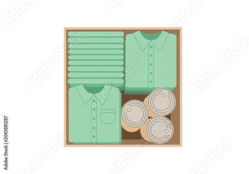 Top view of a cardboard box packed with folded green shirts and canned goods