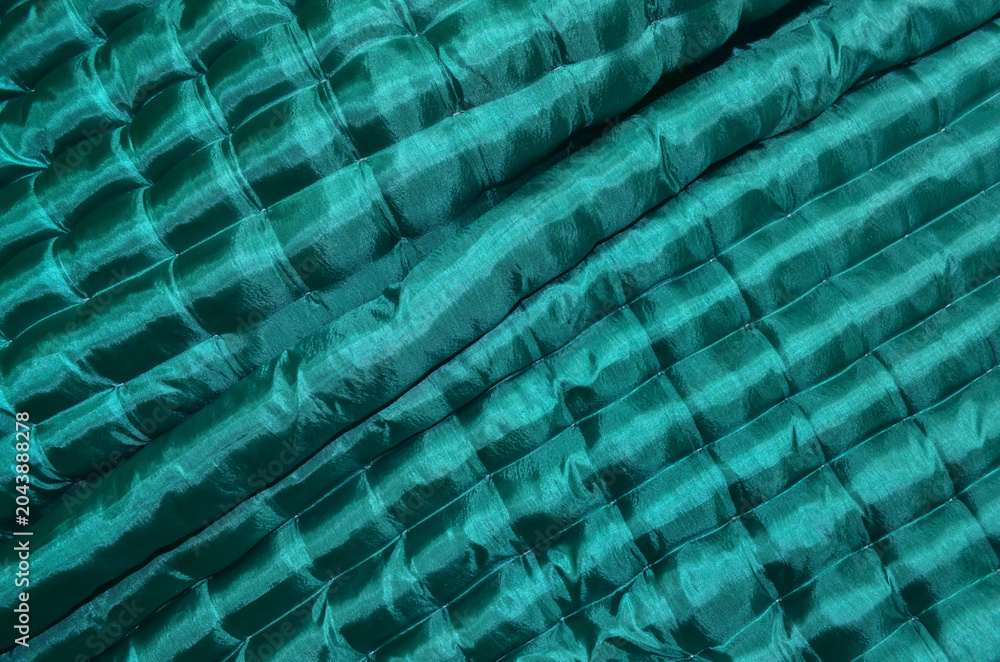 Naklejka premium surface of the floor mattress is green with soft, textured, wavy, and shiny fabric.