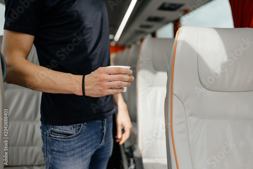 Foto Passenger enjoys a refreshing drink in a comfortable, modern coach interior duri