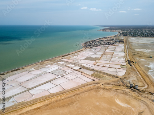 Photos Aerial view of salt evaporation ponds with white salt mounds near Caribbean coas