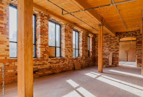 Industrial loft interior with exposed brick walls during office renovation project.