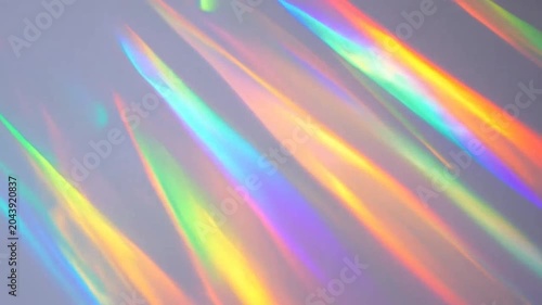 Vibrant rainbow light streaks cast across a smooth neutral surface