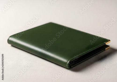 A sleek dark green leather passport cover with gold corner accents rests on a clean white surface.