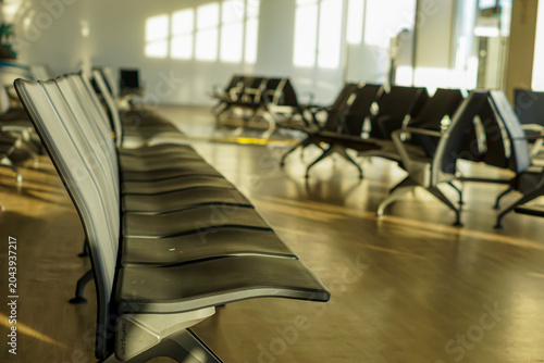 Fotografie Rows of empty terminal seating chairs in a brightly lit modern airport waiting area or transit station lounge