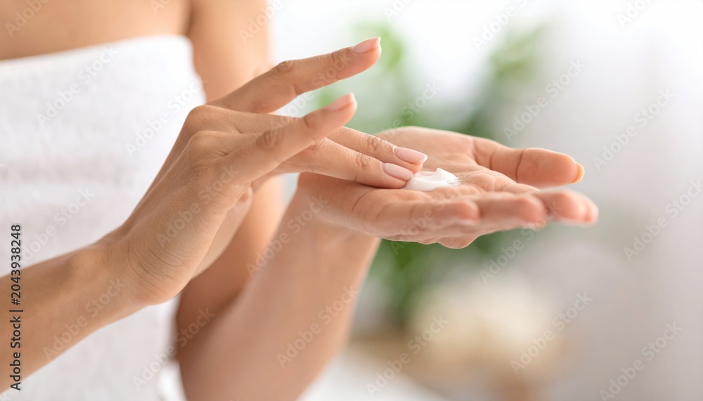Fototapeta premium Hands Applying Moisturizing Lotion in Bright Room.