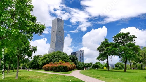 Modern Skyscraper Above Green Urban Park Under Blue Sky