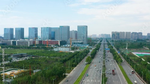Modern urban skyline with office towers and highway traffic under blue sky
