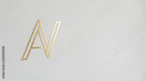 Modern gold metallic logo on a minimalist white wall