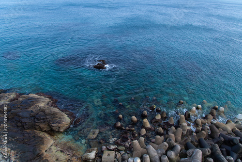 Coastal rock formation and tetrapods by the blue ocean