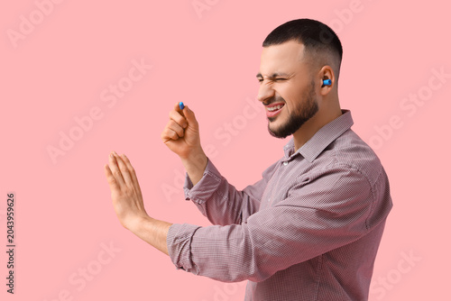 Young man with earplugs suf...