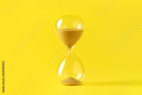 Hourglass on yellow backgro...