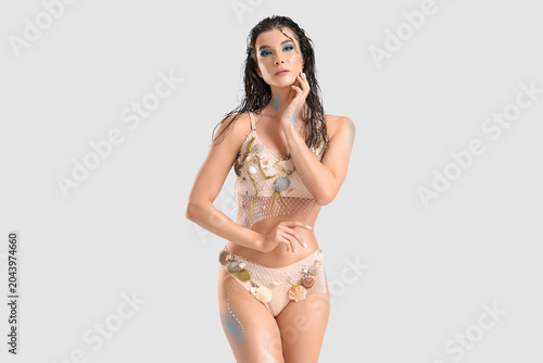 Photos Beautiful young woman dressed as mythical mermaid on grey background