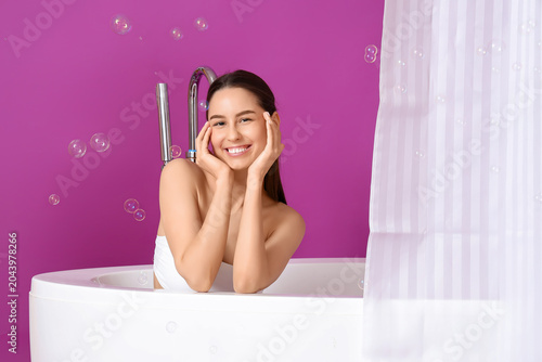 Young woman in bathtub with...