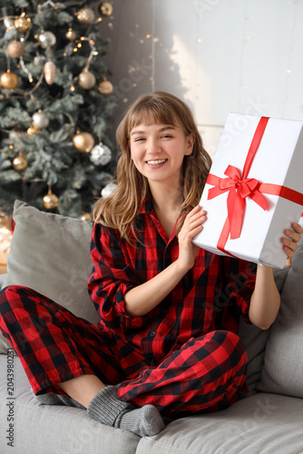 Happy young woman in pajama...