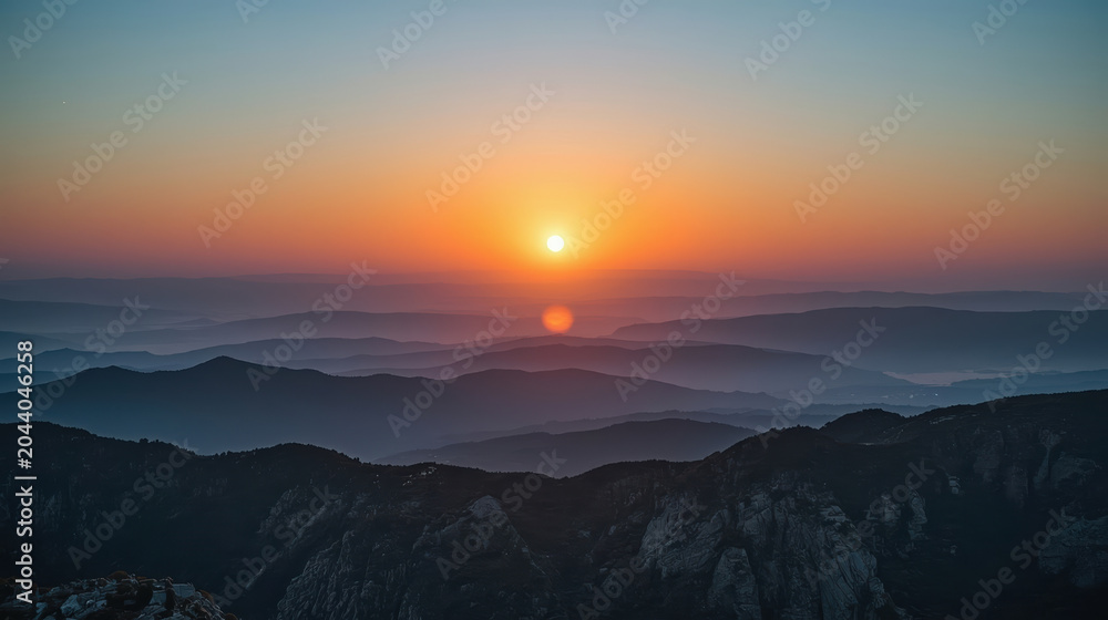 Obraz premium Sunrise mountain layers horizon glowing serene light mist