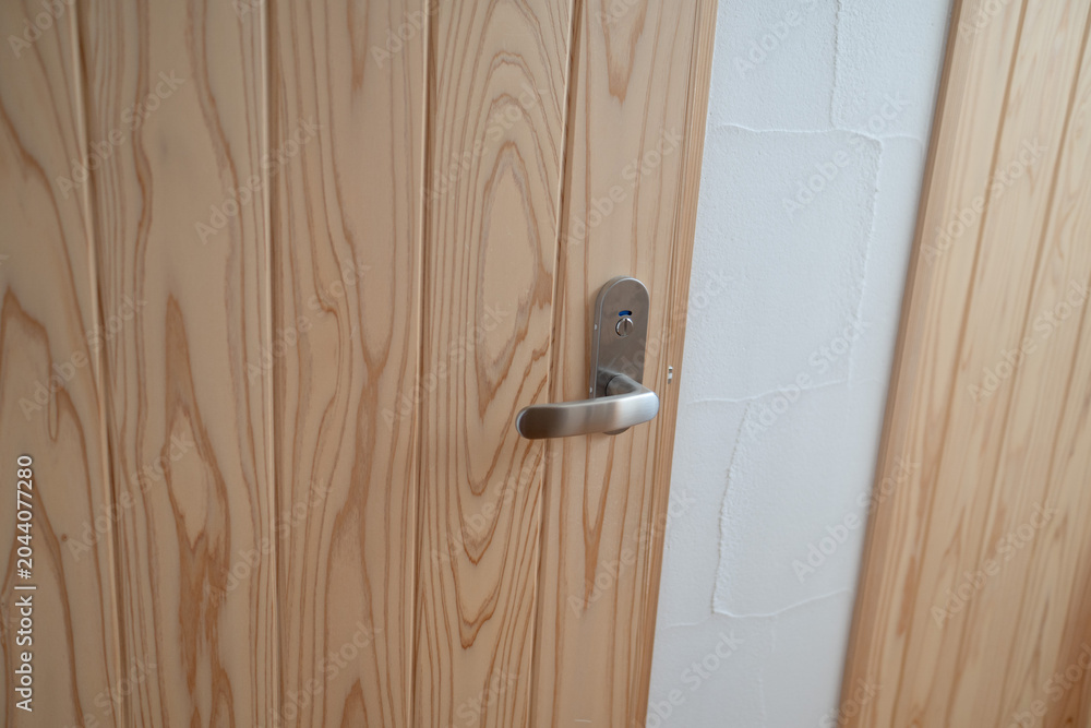 Fototapeta premium Natural Wood Hinged Door With Metal Door Handle（一軒家の木目が美しい木製ドアと金属のドアノブ）