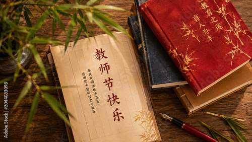 Teachers Day celebration with books and bamboo on a wooden table indoors