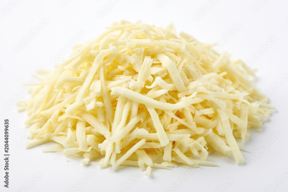Fototapeta premium A pile of shredded white cheese on a white background, ready for cooking or garnishing dishes.