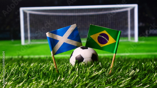 Konstfotografi Soccer ball on green grass with scottish and brazilian flags in front of a goal