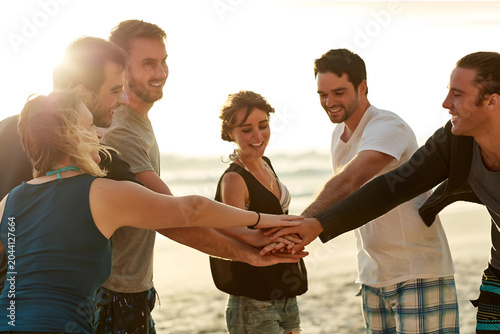Diverse Group of Friends Stacking Hands Together on Beach – Unity, Culture & Community