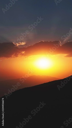 Timelapse cinematic golden sunset mountains sun rays piercing clouds dramatic sky silhouette nature landscape spiritual hope inspiration light rays wilderness horizon outdoor vista. Gods suns eye